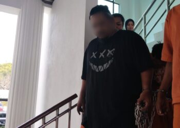 SUSPEK (baju hitam) diiringi anggota polis ketika dibawa ke Mahkamah Majistret, Alor Gajah, Melaka untuk mendapatkan permohonan reman. - UTUSAN/MUHAMMAD SHAHIZAM TAZALI