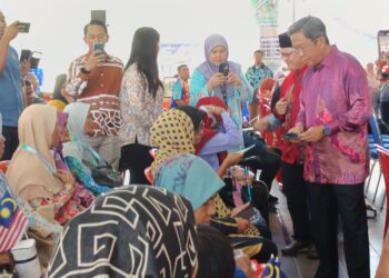 JALALUDDIN Alias (kanan) menyampaikan zakat kepada asnaf pada program Hari Informasi Pertanian Daerah Rembau Sempena Sambutan Hari Kebesaran Islam Peringkat Daerah Rembau di Rembau hari ini.-UTUSAN/NOR AINNA HAMZAH.