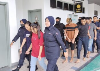 KESEMUA tertuduh diiring anggota polis ketika dihadapkan ke Mahkamah Majistret, Ayer Keroh, Melaka. - UTUSAN/MUHAMMAD SHAHIZAM TAZALI