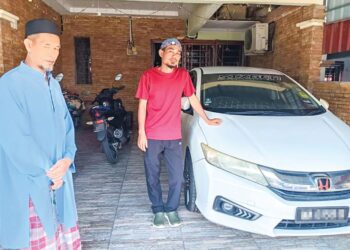 MOHD. Yusof Mokhtar sambil diperhatikan bapa mentuanya, Ahmad Rozi Latimin menunjukkan kereta arwah isterinya di Kota Masai, Pasir Gudang.