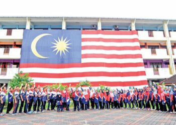 WARGA Sekolah Kebangsaan (SK) Taman Pelangi Indah, Johor Bahru menunjukkan Jalur Gemilang gergasi yang digantung di bangunan sekolah itu sempena sambutan ulang tahun Hari Kemerdekaan Ke-67 dan Bulan Kebangsaan.
– UTUSAN/RAJA JAAFAR ALI