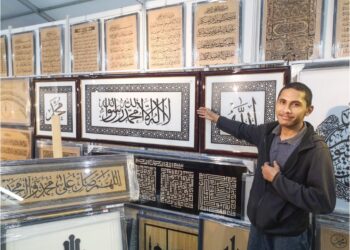 PEKERJA Family Trading Framing, Woodlock & Laser Craft, Firdaus Rohami menunjukkan produk seni khat kreatif yang dihasilkan menggunakan teknologi laser. – UTUSAN/NUR SHARIEZA ISMAIL