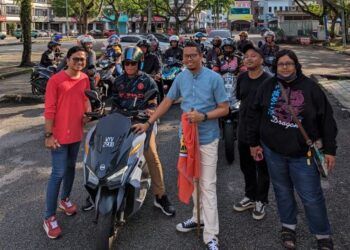 MUHAMMAD Izuan bergambar bersama sekumpulan penunggang motosikal.