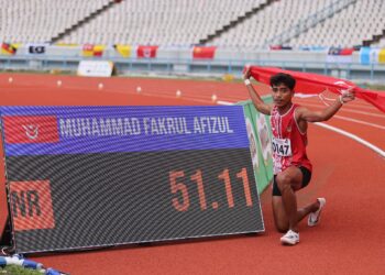 Atlet Kelantan, Muhammad Fakrul Afizul Nasir disamping paparan catatan masa 51.11 saat yang menjadi rekod kebangsaan baharu dalam acara akhir 400 meter lari berpagar lelaki.-UTUSAN/MUHAMAD IQBAL ROSLI