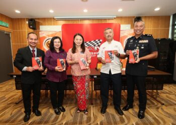 MOKHZANI (dua kanan) dan Hannah (tengah) menunjukkan buku Garis Panduan Sukan Pemotoran Drag dan Motocross Malaysia di Bukit Jalil, Kuala Lumpur, semalam. - IHSAN MAM