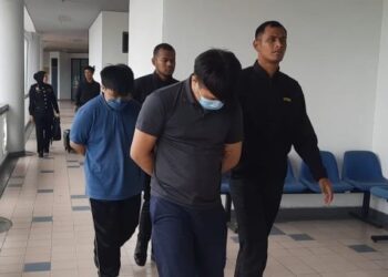 KEDUA-DUA tertuduh diiringi pegawai SPRM ketika dihadapkan
ke Mahkamah Sesyen Ayer Keroh, Melaka.