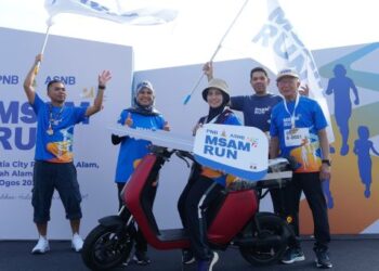 Pengerusi Kumpulan PNB, YM Raja Tan Sri Dato' Seri Arshad Raja Tun Uda (kanan) menyampaikan sebuah e-bike kepada pemenang hadiah utama cabutan bertuah MSAM Run, Rossilawati Abd Gani, dari Kota Damansara.