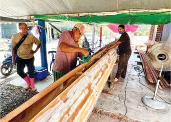 WAHAB Abdullah (kiri) menyiapkan bot panjang yang akan digunakan dalam perlumbaan Pesta Air Kuala Perlis September depan di Kuala Perlis, semalam. – UTUSAN/ASYRAF MUHAMMAD