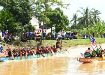 GURU dan pelajar SMK Syed Ahmad berlumba sambil mengibar Jalur Gemilang sempena sambutan Bulan Kebangsaan peringkat sekolah itu di Sungai Tambun Tulang, Arau, Perlis, semalam. - UTUSAN/IZLIZAN OTHMAN