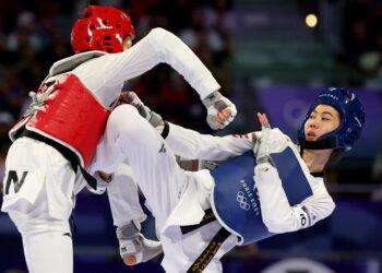 AKSI Atlet Thailand Panipak Wongpattanakit (kana) ketika menentang wakil China Guo Qing pada final acara taekwondo wanita flyweight 49kg di Grand Palais.-AFP