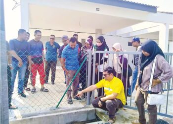 SEBAHAGIAN pembeli melihat kesan kerosakan di bahagian hadapan salah satu unit Taman Residensi Mesra Fasa 1 yang masih belum boleh diduduki di Gurun. – UTUSAN/OTHMAN YAHAYA