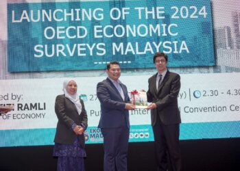 RAFIZI Ramli menerima buku laporan OECD daripada wakil OECD Dr Luiz De Mello (kanan) pada Majlis Pelancaran Kajian Ekonomi Malaysia OECD 2024 di Putrajaya. - UTUSAN/FAISOL MUSTAFA