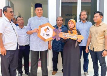 HUSAM Musa  menyerahkan replika kunci rumah kepada Suhaini Mohamad Asri di Kampung Gong Datuk, Pasir Puteh, Kelantan, semalam. – UTUSAN/TOREK SULONG.