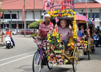 KAMARUDIN Md. Nor (kanan) dibawa menaiki beca mengelilingi bandar Kota Bharu semalam. – UTUSAN/MUSTAQIM MOHAMED