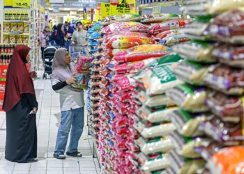 Seorang pelanggan membuat pilihan semasa membeli Beras Putih Import (BPI) ketika tinjauan stok beras putih di sebuah pasar raya di sini, baru-baru ini. – utusan/ FARIZ RUSADIO