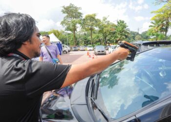 Seorang petugas mengimbas  pelekat RFID pada kenderaan Singapura yang membuat pendaftaran Permit Masuk Kenderaan (VEP) di Danga Bay, Johor Bahru . – UTUSAN/RAJA JAAFAR ALI