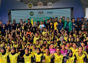 FADHLINA (belakang, tengah) bersama peserta Program FIFA Football For School dan Kempen Bola Sepak Wanita FIFA di Sekolah Kebangsaan (SK) Tasek Permai, Simpang Ampat, Nibong Tebal, Pulau Pinang.