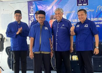 CHE Ariffin Hussin (kiri) bersama Ahmad Zahid Hamidi selepas mengisytiharkan keluar Bersatu untuk menyertai UMNO serta menyerahkan borang pendaftaran keahlian kepada Ahmad Zahid Hamidi di Dewan Kampung Jerek, Gua Musang, Kelantan kelmarin. - UTUSAN/AIMUNI TUAN LAH