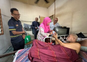 SHAH Inor (tengah) menyerahkan MyKad baharu kepada Sabri di kediamannya di Kampung Surau, Seberang Jaya, Pulau Pinang, semalam