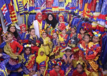 MAHANI Udit (belakang, tengah) bergambar bersama model cilik yang memperagakan busana bertemakan Jalur Gemilang sempena Hari Kemerdekaan di Bukit Jambul, Pulau Pinang.-UTUSAN/IQBAL HAMDAN