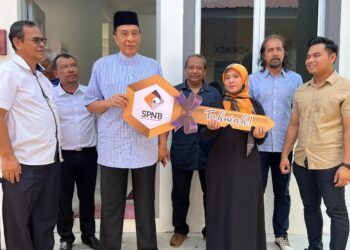 HUSAM Musa (dua dari kiri) menyerahkan replika kunci rumah kepada Suhaini Mohamad Asri di Kampung Gong Datuk, Pasir Puteh, Kelantan hari ini. UTUSAN/TOREK SULONG.