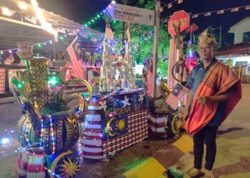 AMIRUDDIN Aman menunjukkan hiasan bertemakan kemerdekaan yang dihasilkannya menggunakan barangan terpakai Ketika ditemui pemberita di Taman Matahari Indah, Senawang, Seremban, semalam.-UTUSAN/NUR SHARIEZA ISMAIL.