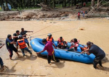 ANGGOTA bomba dan APM membawa keluar mangsa yang terperangkap di tapak perkhemahan Risda Eco-Park, Kampung Ulu Slim, Slim River hari ini berikutan kejadian kepala air  semalam. - UTUSAN/MUHAMAD NAZREEN SYAH MUSTHAFA