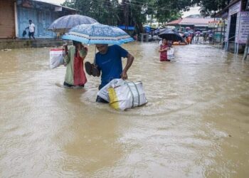 PENDUDUK terpaksa meredah banjir untuk berpindah ke tempat lebih selamat.- AGENSI