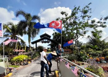 Md. Salman Daud ( tengah  ) bersama ahli keluarga  memasang bendera Johor  di Kangs Homestay di Kampung Parit Puteri Menangis, di Pontian, Johor, disini, baru-baru ini. - UTUSAN/MUHAMMAD ZIKRI