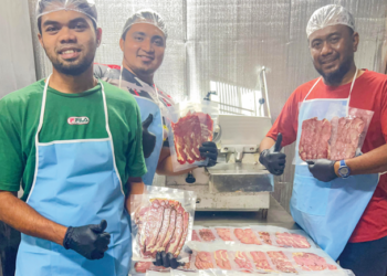 MOHD. Farhan Sabry (kanan) bersama pekerjanya menunjukkan daging salai yang siap proses untuk pasarkan kepada pelanggan.