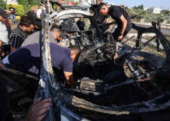 ORANG ramai berhampiran Tulkarm di Tebing Barat memeriksa bangkai kereta yang dilaporkan terkena serangan dron Israel, hari ini.- AFP