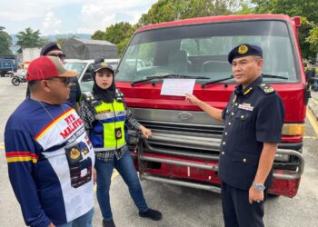 ERICK Jusiang (kanan) menunjukkan lori ‘RORO’ yang ditahan menggunakan nombor pendaftaran palsu pada Operasi Khas Pengarah - Pemandu Warga Asing (PeWA) di sini.