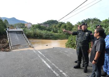 AZIZI Mat Aris (kiri) meninjau lokasi runtuhan Jambatan Slim River-Behrang Ulu, di Slim River hari ini. - UTUSAN/ZULFACHRI ZULKIFLI