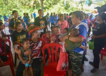 MOHD. Azmawi Fikri Abdul Ghani (kiri) menyantuni masyarakat Orang Asli yang merupakan penduduk di Kawasan DUN Nenggiri, Gua Musang, Kelantan.