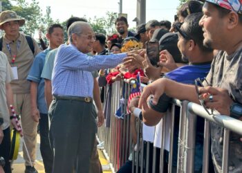 MAHATHIR Mohamad bersalaman dengan orang ramai ketika hadir sambutan Hari Kebangsaan 2024.