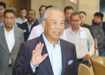 MUHYIDDIN Yassin melambaikan tangan semasa keluar dari pejabat Lembaga Pembangunan Pelaburan Malaysia (MIDA) di Kuala Lumpur, semalam. - UTUSAN/AMIR KHALID