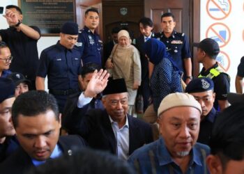 MUHYIDDIN Yassin  melambaikan tangan selepas menghadiri prosiding perbicaraan di Mahkamah Sesyen Gua Musang, Kelantan, semalam. - UTUSAN/KAMARUL BISMI KAMARUZAMAN