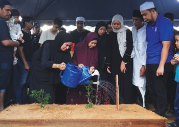 AHLI keluarga menyiram air ke atas pusara Allahyarham Muhammad Nidza Afham Mokhtar semasa majlis pengkebumian di Tanah Perkuburan Islam Puncak Alam, Selangor, semalam. – UTUSAN/NURUL NAJWA