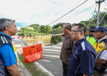 MOHAMAD Nizar Jamaluddin dan Chang Lih Kang meninjau jambatan yang runtuh akibat kejadian kepala air di Slim River di Tanjung Malim hari ini. - UTUSAN/MUHAMAD NAZREEN SYAH MUSTHAFA