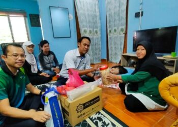 MOHD. Sabirin Mohd. Sarbini (dua kanan) menyerahkan bantuan zakat
kepada keluarga yang memerlukan.