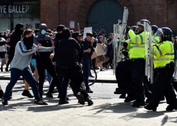 Polis berdepan dengan sekumpulan perusuh dengan slogan `Enough is Enough’ di Liverpool kelmarin. – AFP