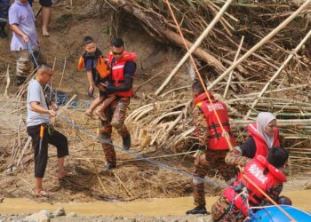 ANGGOTA bomba memindahkan mangsa yang terperangkap di Risda Eco Park di Slim River hari ini akibat kejadian kepala air yang berlaku semalam. - UTUSAN/IHSAN JBPM