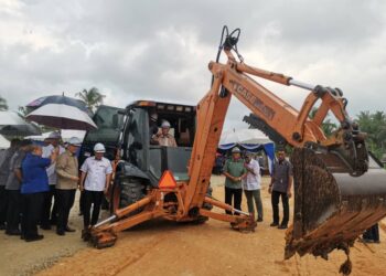 AHMAD Zahid Hamidi mengendalikan jengkaut pada Majlis Pecah Tanah Projek Pemajuan Kawasan RPT Simpang Tiga di Bagan Datuk hari ini. - UTUSAN/AIN SAFRE BIDIN