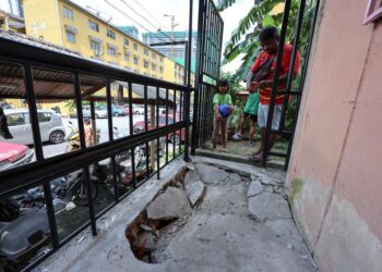 PENDUDUK meninjau keadaan mendapan tanah yang berlaku di belakang sebuah unit rumah sekitar Pangsapuri Taman Keramat Permai, Kuala Lumpur. - UTUSAN/AMIR KHALID