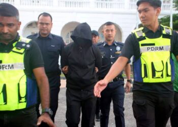 MOHD. Nazri Abdul Razak (tengah) diiringi anggota polis semasa tiba di Mahkamah Tinggi Ipoh, Perak, semalam.