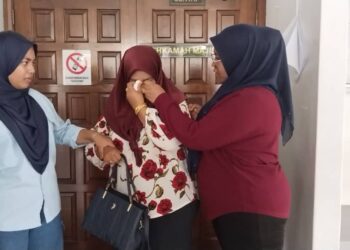 NORIZAN Mat Isa (tengah) kelihatan sebak dan ditenangkan dua anaknya sejurus selepas keluar daripada Mahkamah Majistret Ayer Keroh, Melaka.