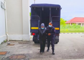 TERTUDUH diiringi polis semasa menghadiri prosiding perbicaraan di Mahkamah Sesyen, Kota Bharu, Kelantan hari ini-UTUSAN/YATIMIN ABDULLAH.