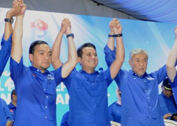 PENGERUSI Barisan Nasional (BN), Datuk Seri Dr. Ahmad Zahid Hamidi (kanan) dan Pengerusi UMNO Johor, Datuk Onn Hafiz Ghazi mengangkat tangan Syed Hussien Syed Abdullah (tengah) yang mewakili parti itu pada Pilihan Raya Kecil (PRK) Dewan Undangan Negeri (DUN) Mahkota semasa majlis pengumuman calon 
di Kluang, Johor, Sabtu lalu. – UTUSAN/RAJA JAAFAR ALI