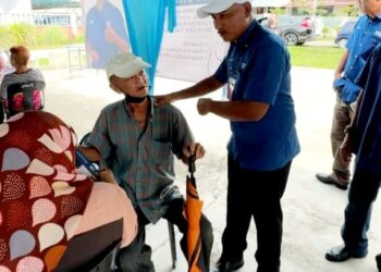 MOHAMAD HAIZAN Jaafar  (kiri) berbual dengan seorang warga emas semasa berkempen di Jalan Gajus, Taman Lian Seng, Kluang.