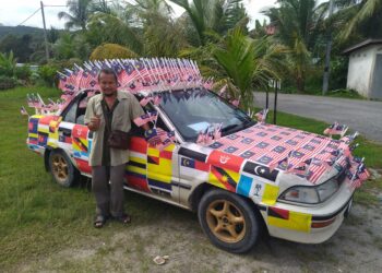 ROSLI Jalaluddin menunjukkan keretanya yang memenangi pertandingan kereta berhias di Kuala Kangsar. – UTUSAN